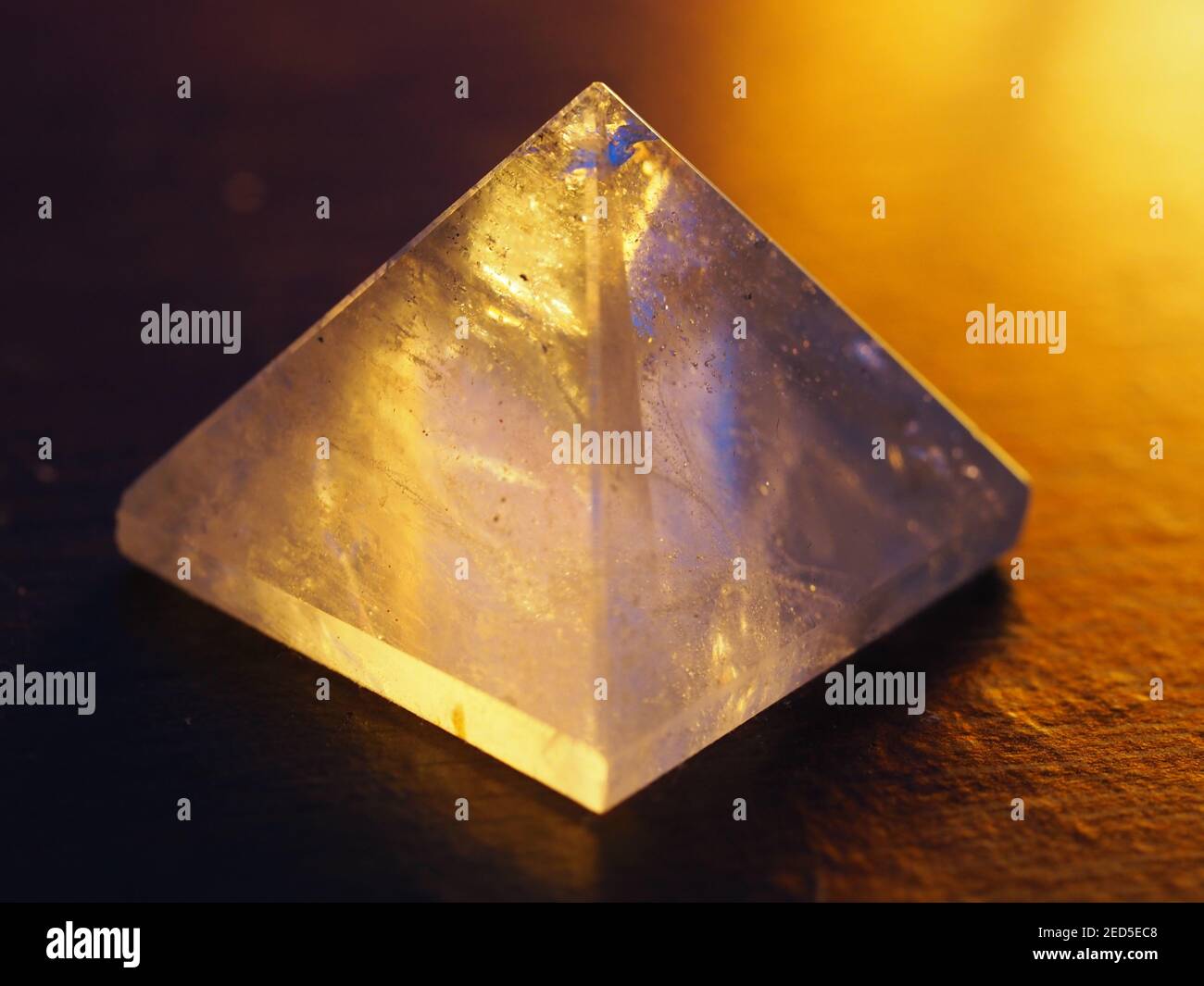 Piramide in cristallo al quarzo trasparente con retroilluminazione e luce calda morbida Foto Stock