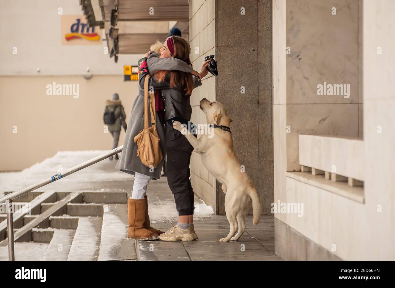 Praga, Repubblica Ceca. 02-13-2021. Momento emozionale di due amici di ragazza che abbracciano quando si incontrano con il cane che partecipa alla riunione in città Foto Stock