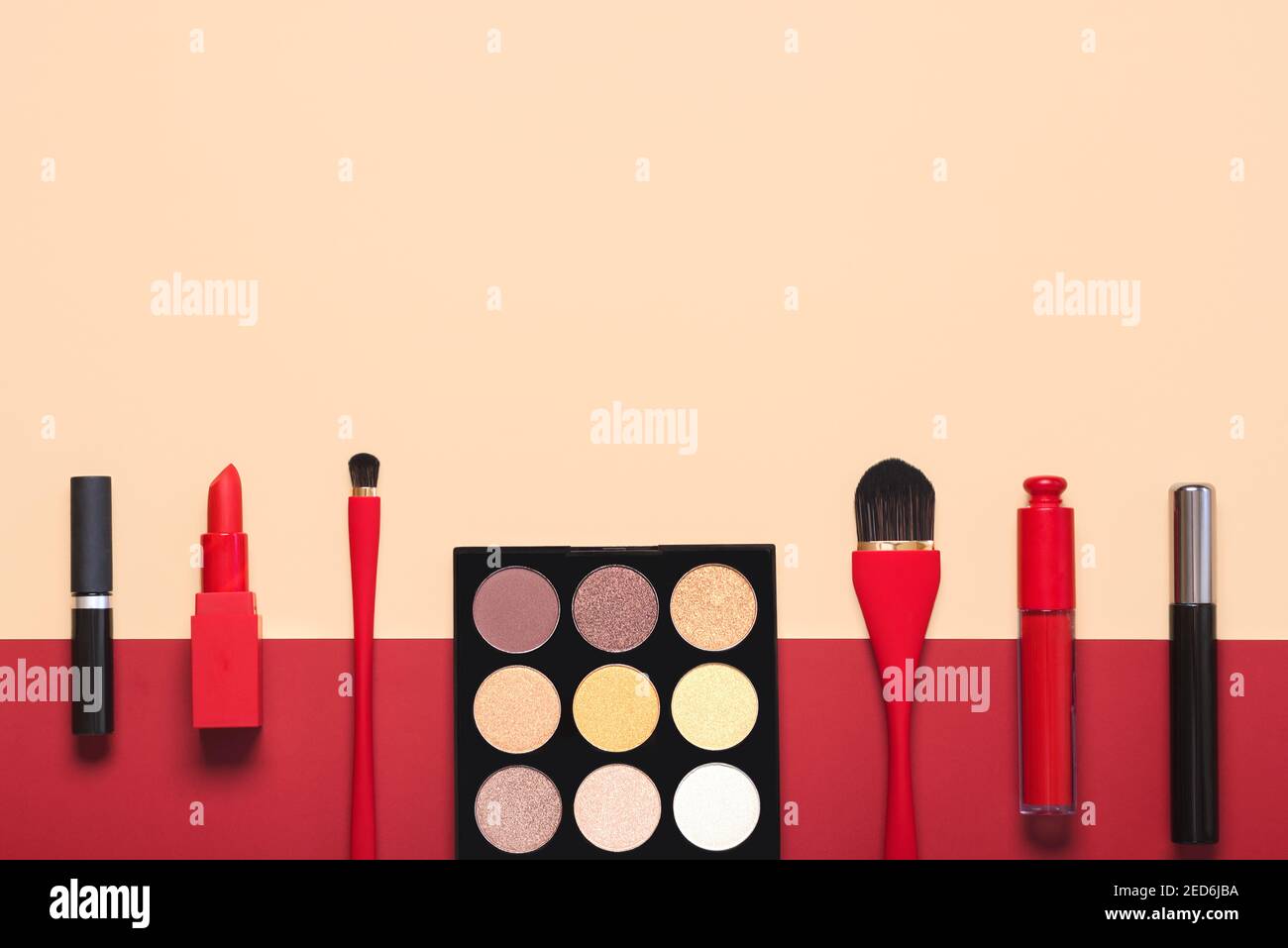 Cosmetici e accessori diversi make-up femminile su un beige e. Red background.Make Up Beauty Fashion Concept Foto Stock