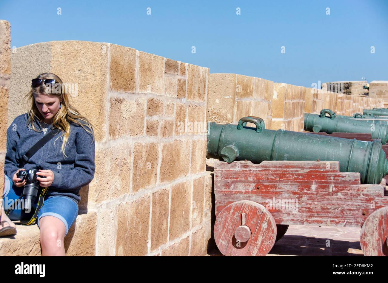 Bionda ragazza turistica guardando la sua fotocamera DSLR a Essaouira Marocco Foto Stock