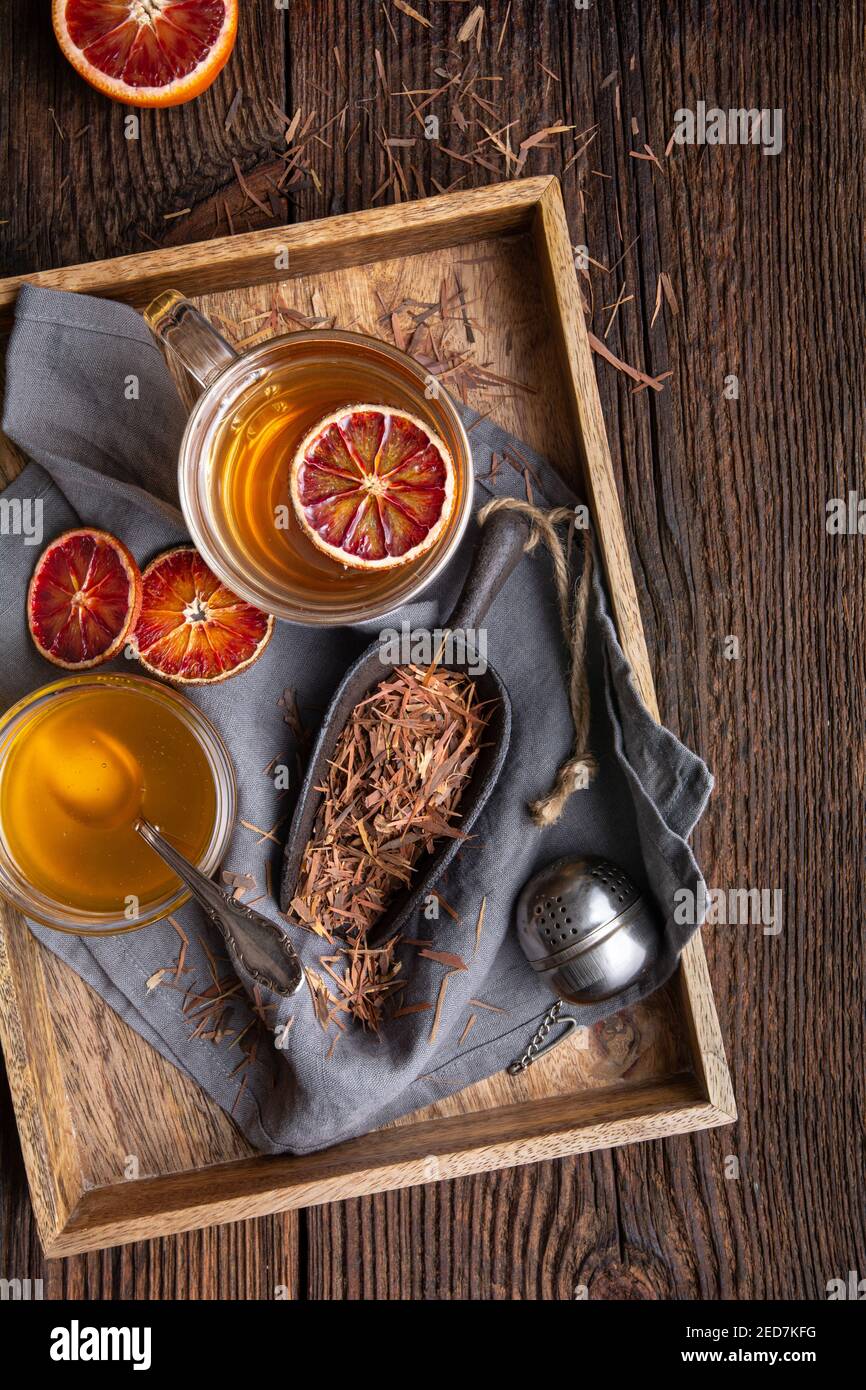 Il tè della corteccia del Pau d'Arco medicinale conosciuto anche come Lapacho in una tazza di vetro su sfondo di legno Foto Stock
