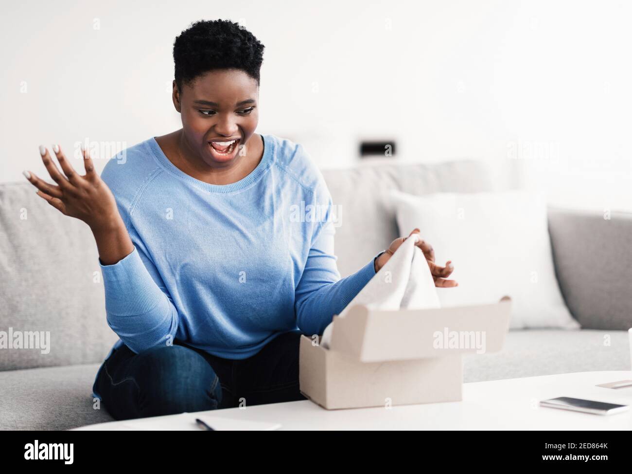 Frustrata donna nera disimballare scatola sbagliata, errore di consegna Foto Stock