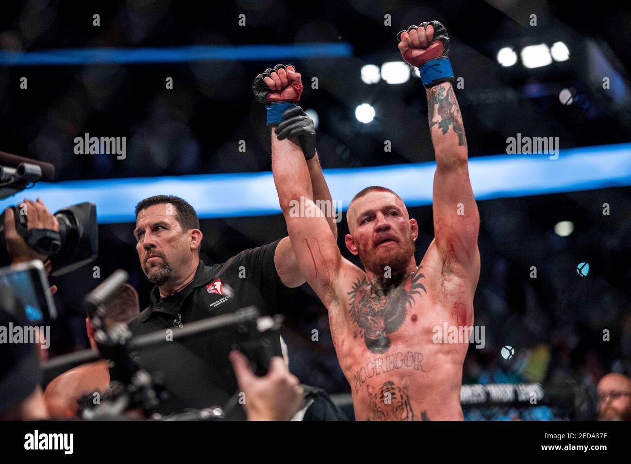 20 agosto 2016; Las Vegas, NV, USA; Conor McGregor (guanti blu) reagisce a  combattere con Nate Diaz (guanti rossi) durante UFC 202 alla T-Mobile  Arena. Credito obbligatorio: Joshua Dahl-USA TODAY Sports /