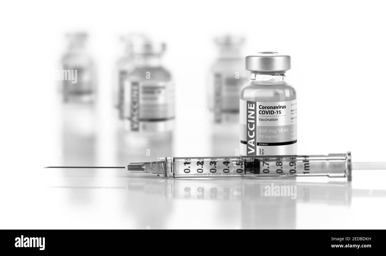 Flaconcini e siringa per vaccino per coronavirus COVID-19 su superficie riflettente. Foto Stock