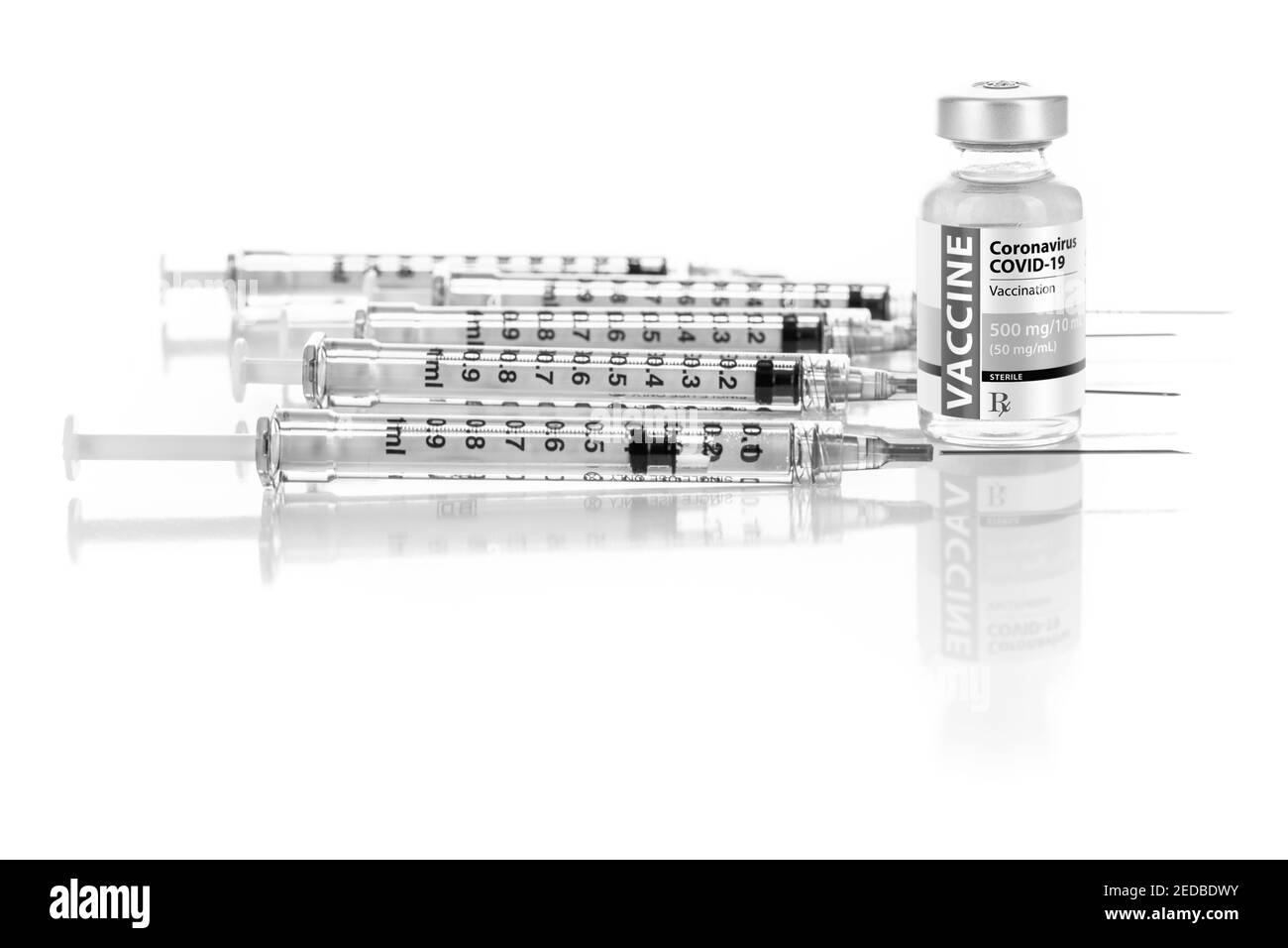 Fiala per vaccino Coronavirus COVID-19 e diverse siringhe su superficie riflettente. Foto Stock