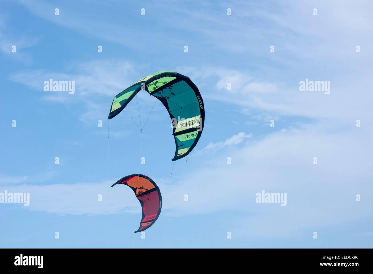 Due vele colorate per il kitesurf volano nel cielo nuvoloso. Mar dei Caraibi, Messico Foto Stock