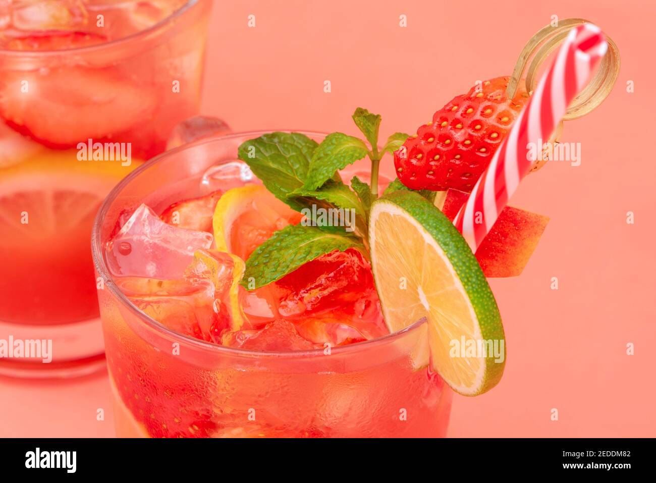 Bevande rinfrescanti e colorate di succo di limonata di fragole con cubetti di ghiaccio nei bicchieri, colpo di primo piano Foto Stock