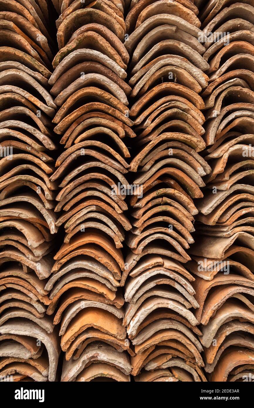 Mattonelle di terracotta accatastate in piles di fondo Foto Stock