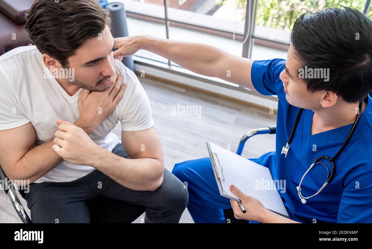 Medico che esamina la spalla ferita del paziente giovane dell'atleta in clinica, concetto di medicina di sport Foto Stock