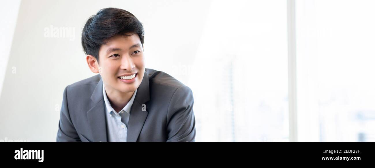 Giovane uomo d'affari cinese sorridente leader asiatico in banner ufficio bianco sfondo Foto Stock