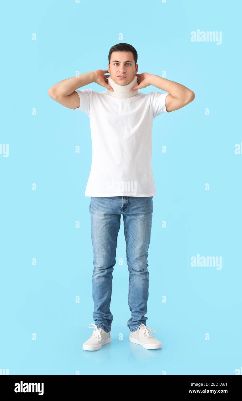 Giovane uomo con colletto cervicale sul collo su sfondo colorato Foto Stock