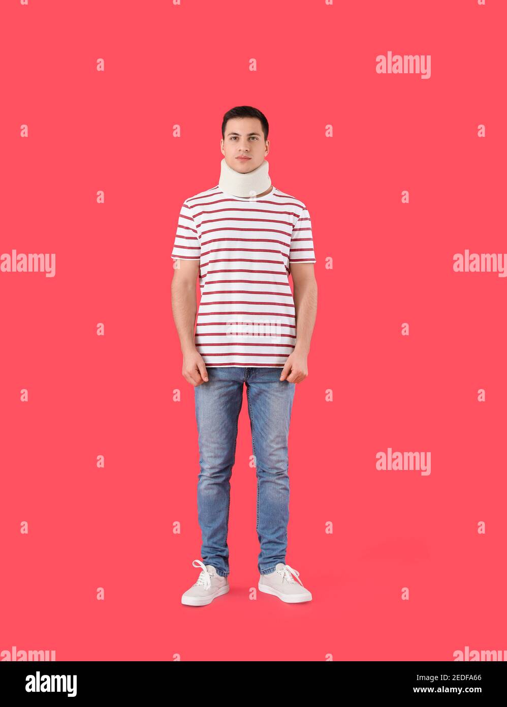 Giovane uomo con colletto cervicale sul collo su sfondo colorato Foto Stock