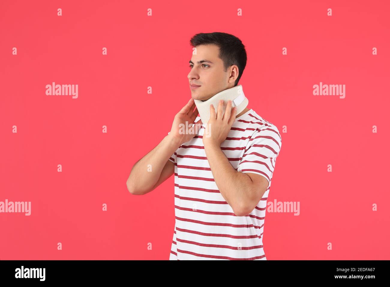 Giovane uomo con colletto cervicale sul collo su sfondo colorato Foto Stock