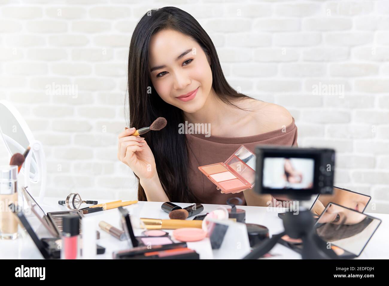Giovane bella donna asiatica professionale di bellezza vlogger o blogger registrazione video tutorial cosmetico per il trucco da condividere sui social media Foto Stock