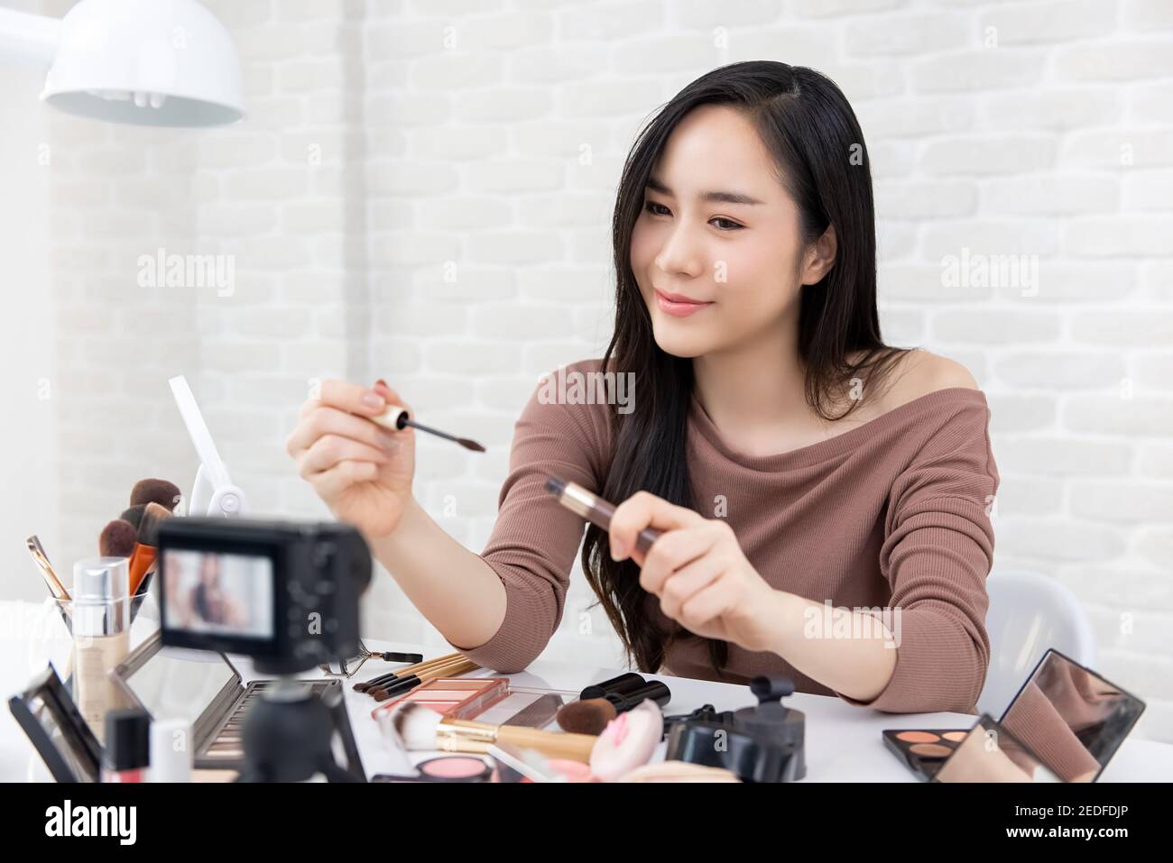 Bella donna asiatica professionale di bellezza vlogger registrazione cosmetica trucco tutorial video da condividere sui social media Foto Stock