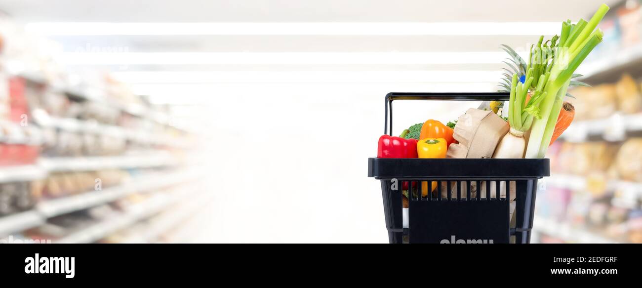 Paniere nero pieno di cibo e generi alimentari nel supermercato sfondo banner corsia con spazio di copia Foto Stock