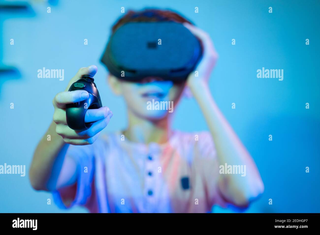 Messa a fuoco selettiva su joystick, giovani bambini che giocano a videogiochi indossando vr o visore per realtà virtuale utilizzando il game pad o il joystick. Foto Stock