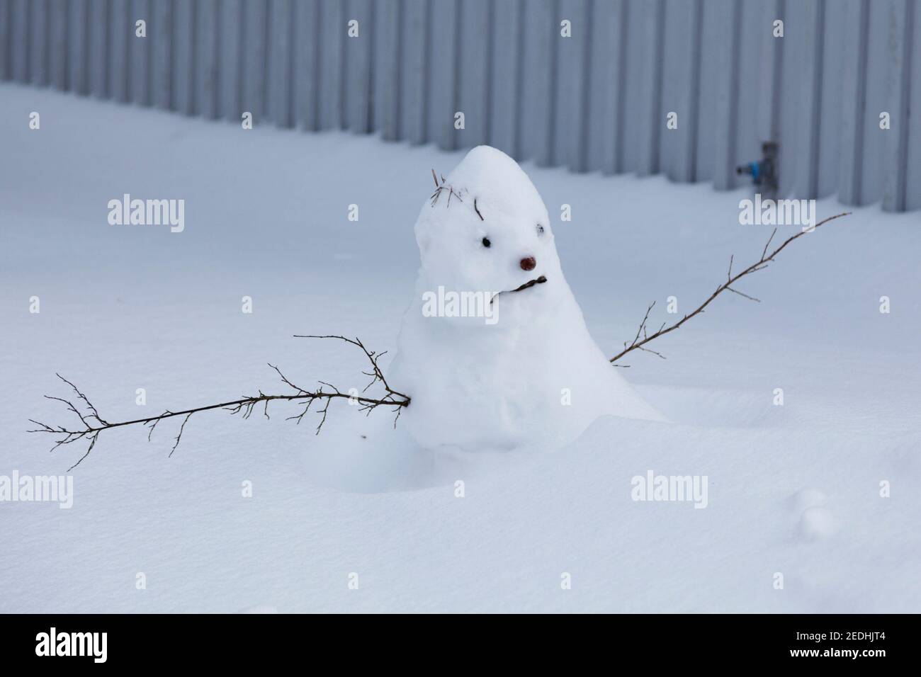 un simpatico pupazzo di neve che si sta sciogliendo lentamente Foto Stock