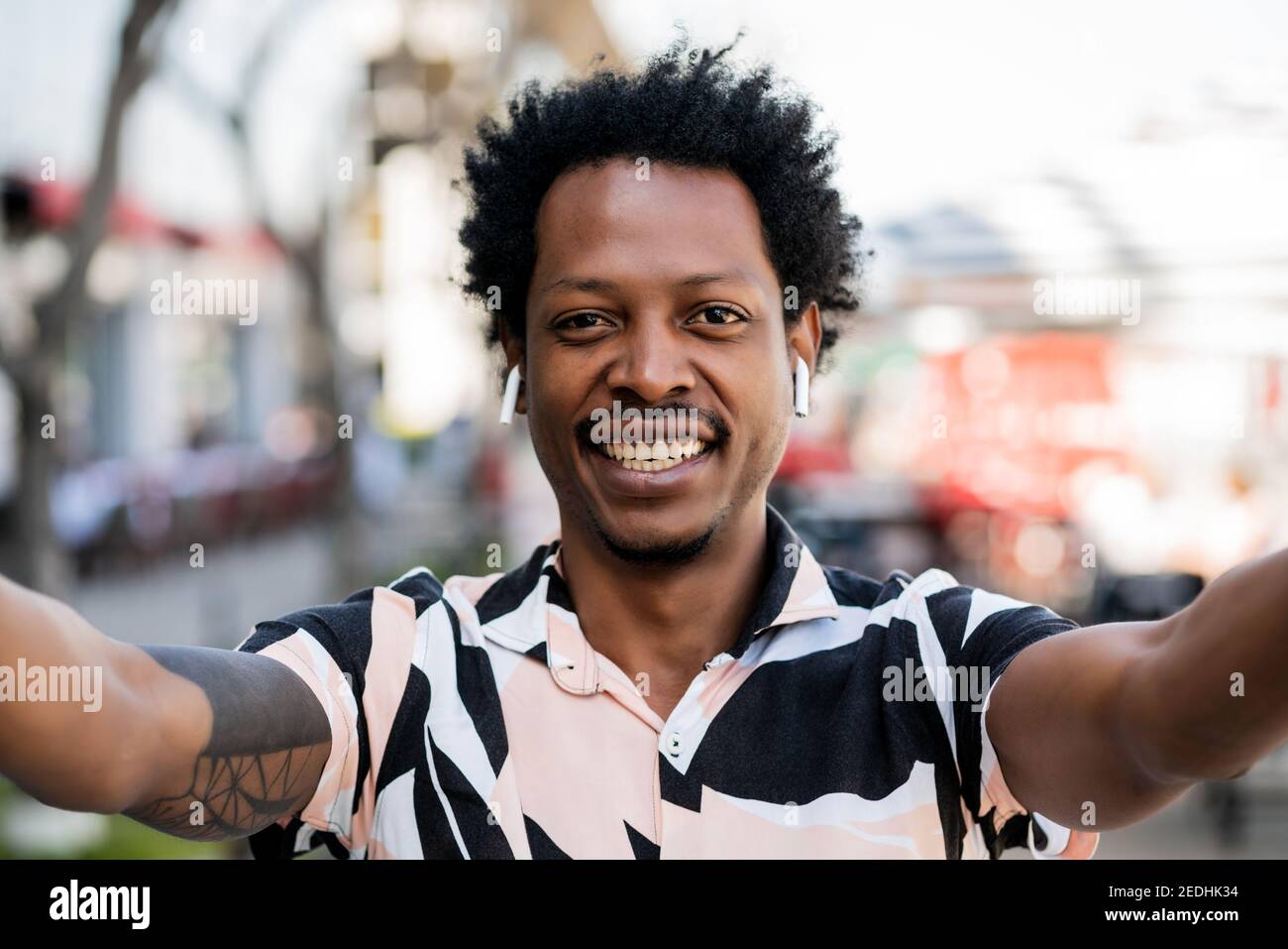 Ritratto di uomo afro che prende un selfie all'aperto. Foto Stock