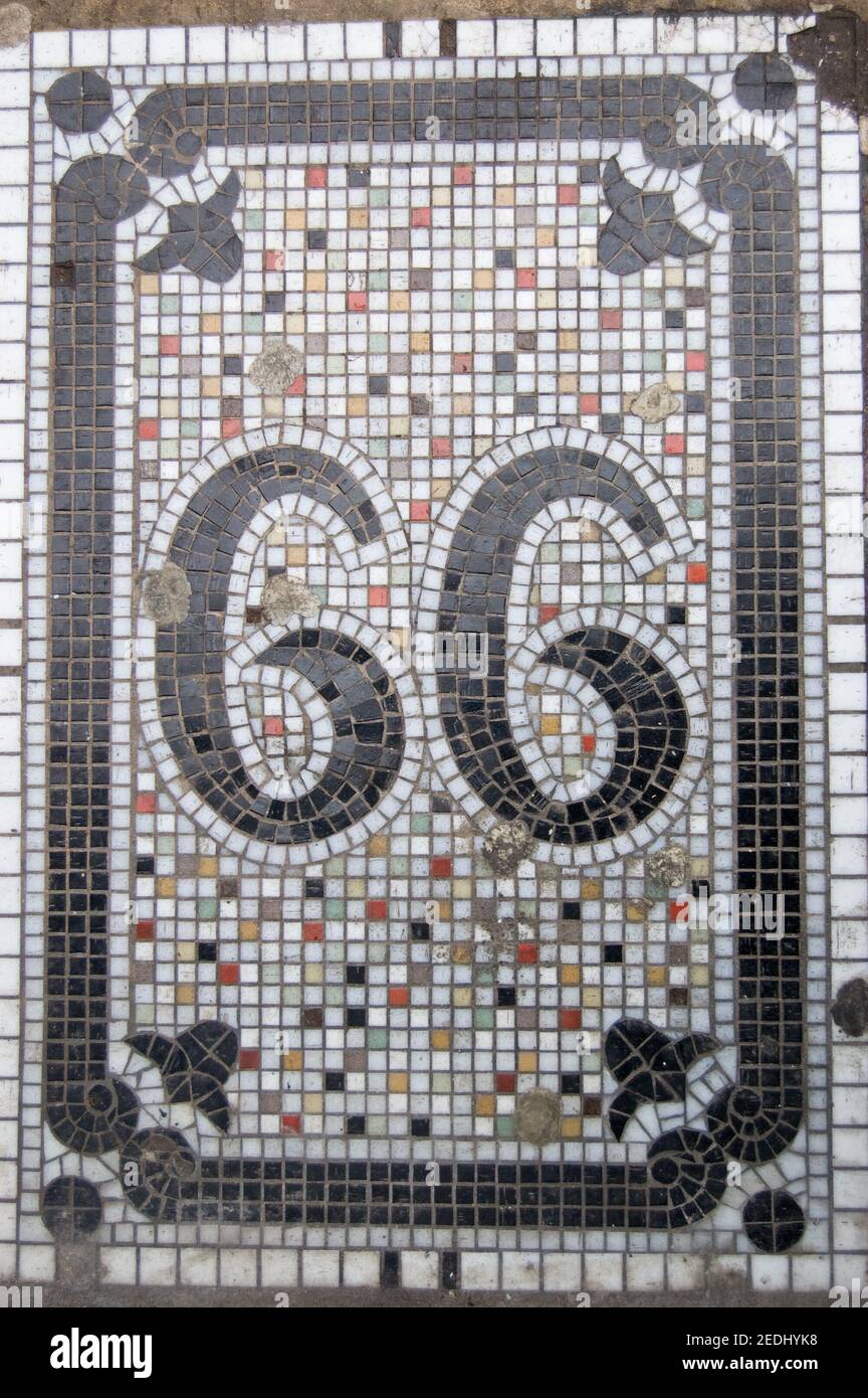 Il numero sessantasei, o novantanove se ruotato. Mosaico vittoriano sul pavimento fuori di un negozio nel centro di Londra. Foto Stock