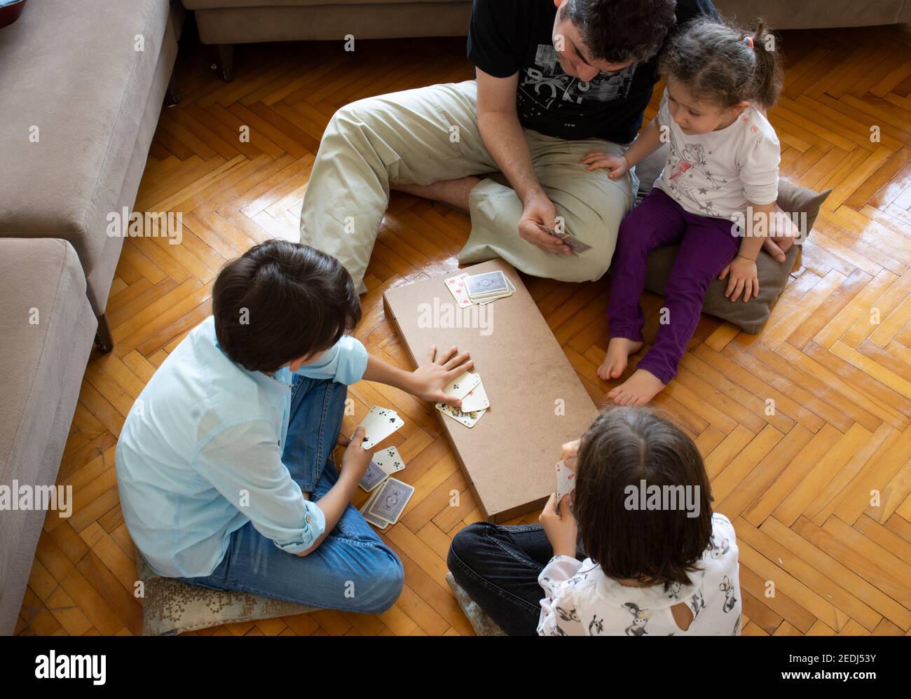 papà e bambini che giocano e imparano a giocare a carte home.stay a casa. week-end alla pandemia Foto Stock