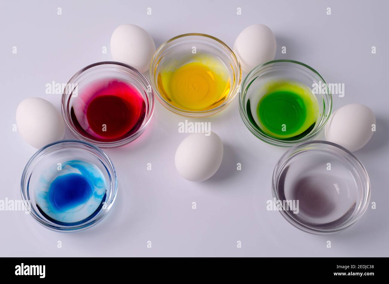 Preparazione per Pasqua, il concetto di colorazione delle uova, materiali per colorare le uova - uova bianche, ciotole d'acqua e l'aggiunta di coloranti colorati. Foto Stock