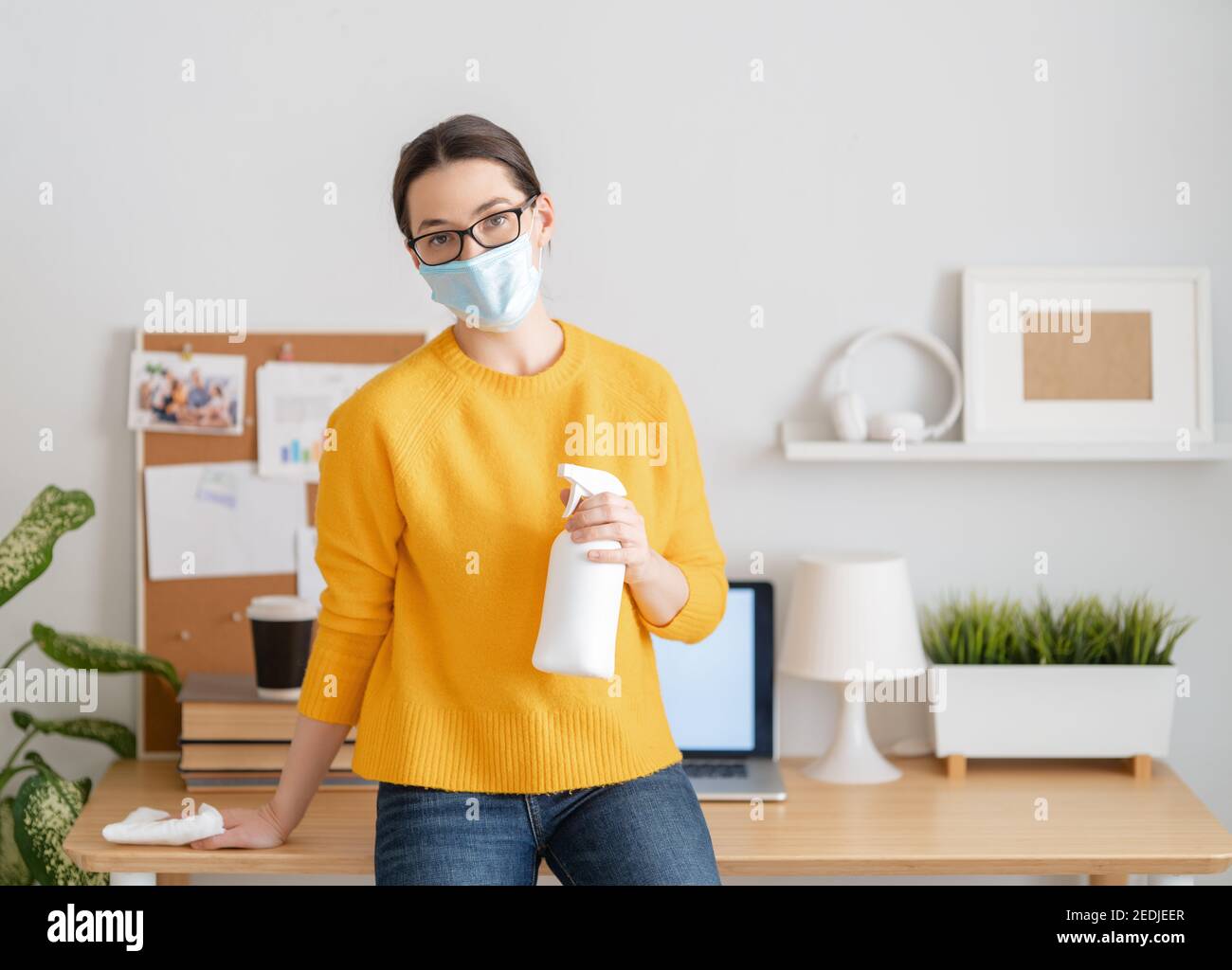 Donna nel facemask che lavora in ufficio domestico. Foto Stock