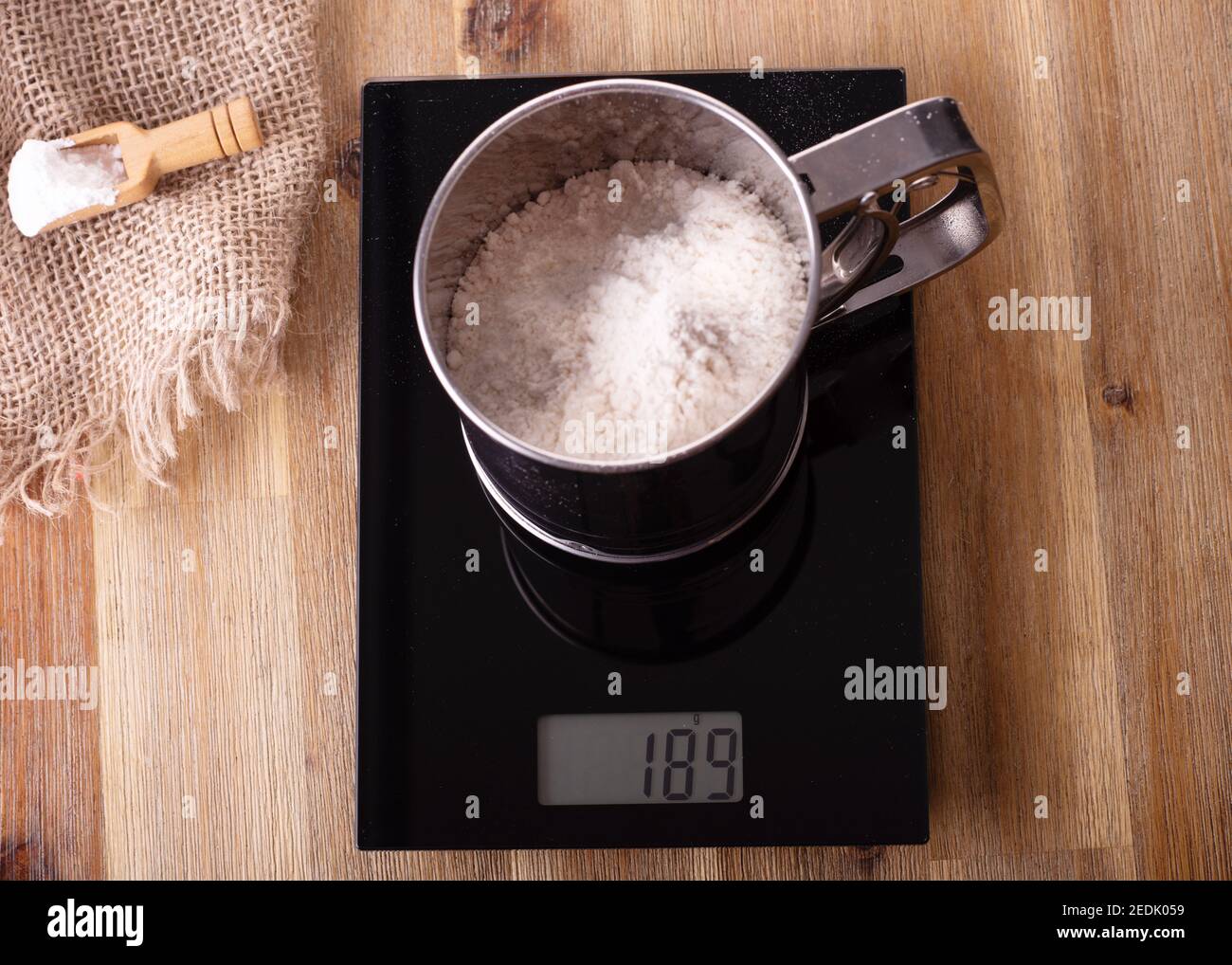 Setaccio per farina setacciato con farina sulla scala farina Setaccio in  acciaio inox con farina sulla bilancia Foto stock - Alamy