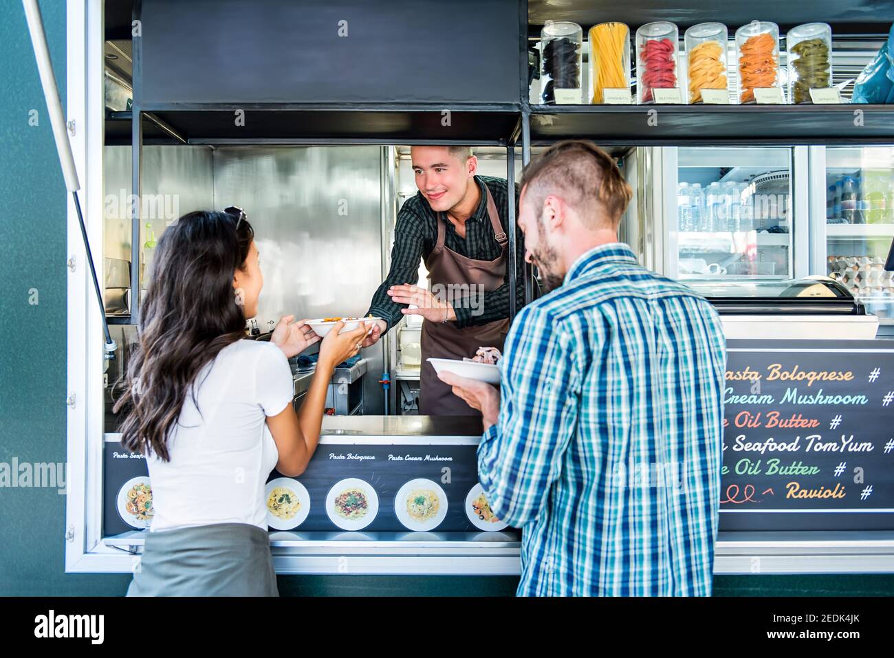 Coppia turistica che acquista pasta dal camion del cibo al mercato all'aperto Foto Stock