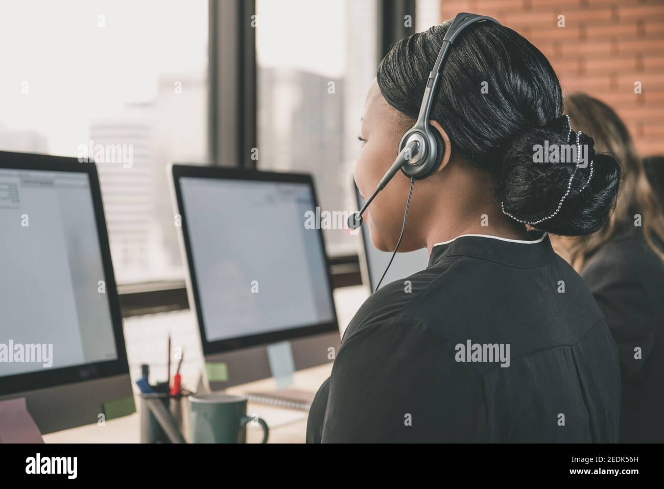 Donna d'affari nera che lavora nel call center come cliente di telemarketing agente di assistenza Foto Stock