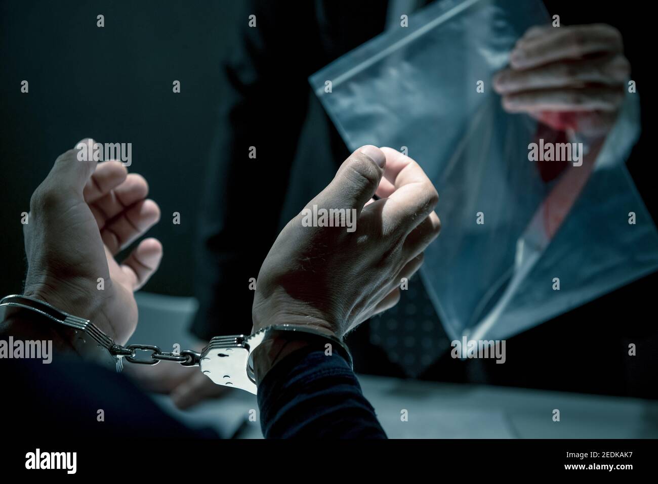 Uomo criminale con manette intervistate nella stanza di interrogatorio per commettere il crimine Foto Stock