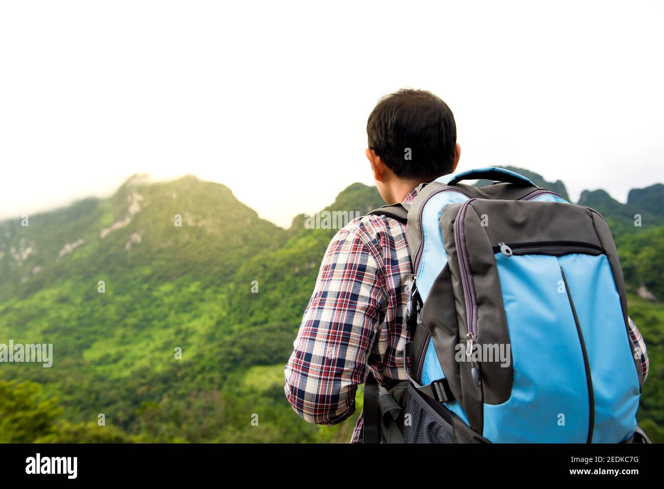 Indipendente turista uomo zaino in spalla guardando bella vista del verde montagna tropicale mentre si viaggia in vacanza Foto Stock