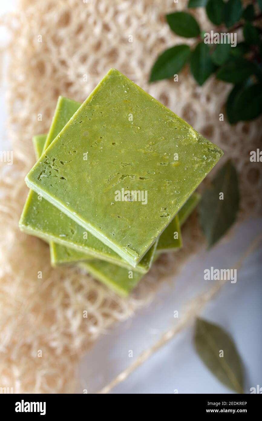 Sapone all'alloro naturale biologico fatto a mano con olio d'oliva e foglie su sfondo bianco. Sapone tradizionale daphne. Foto Stock