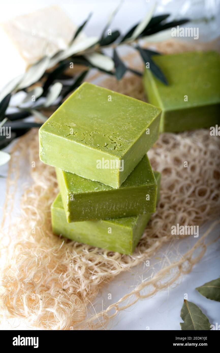 Sapone all'alloro naturale biologico fatto a mano con olio d'oliva e foglie su sfondo bianco. Sapone tradizionale daphne. Foto Stock