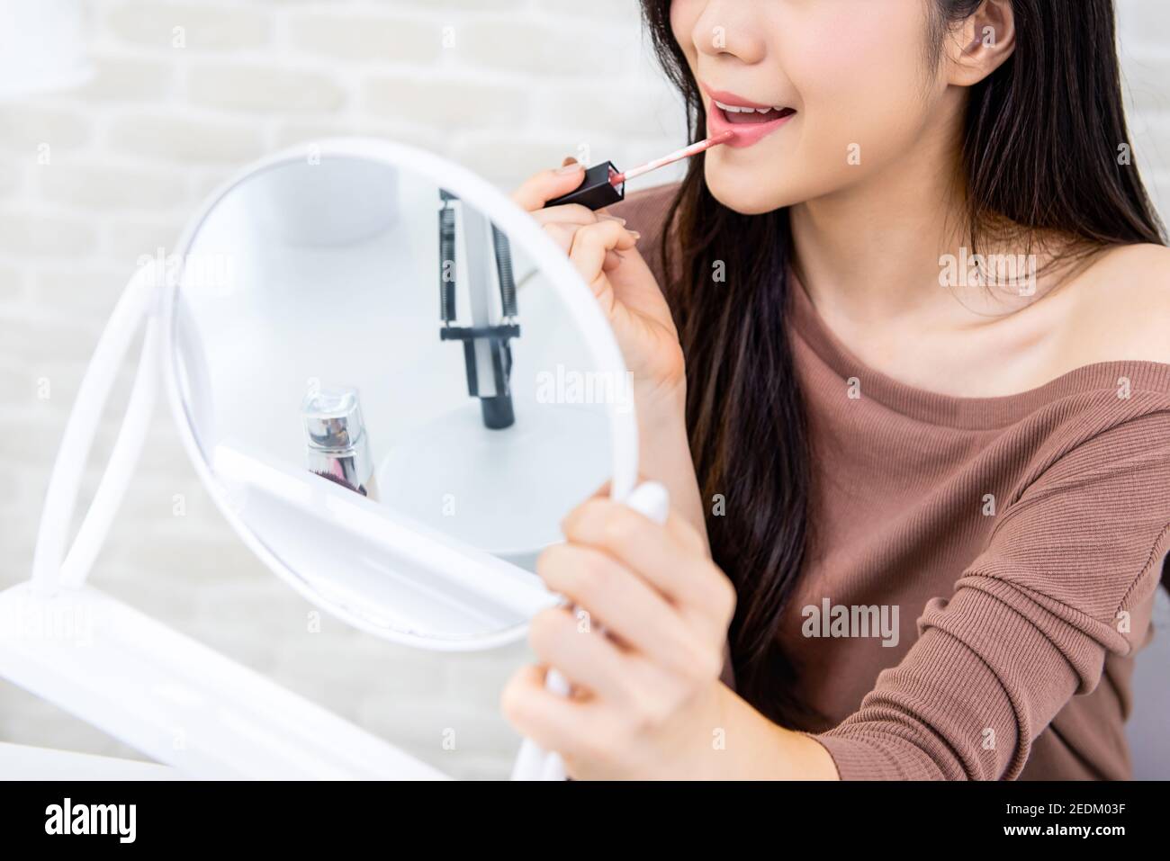 Giovane bella donna professionale di bellezza vlogger o blogger applicando crema di rossetto alla sua bocca, facendo trucco cosmetico tutorial Foto Stock