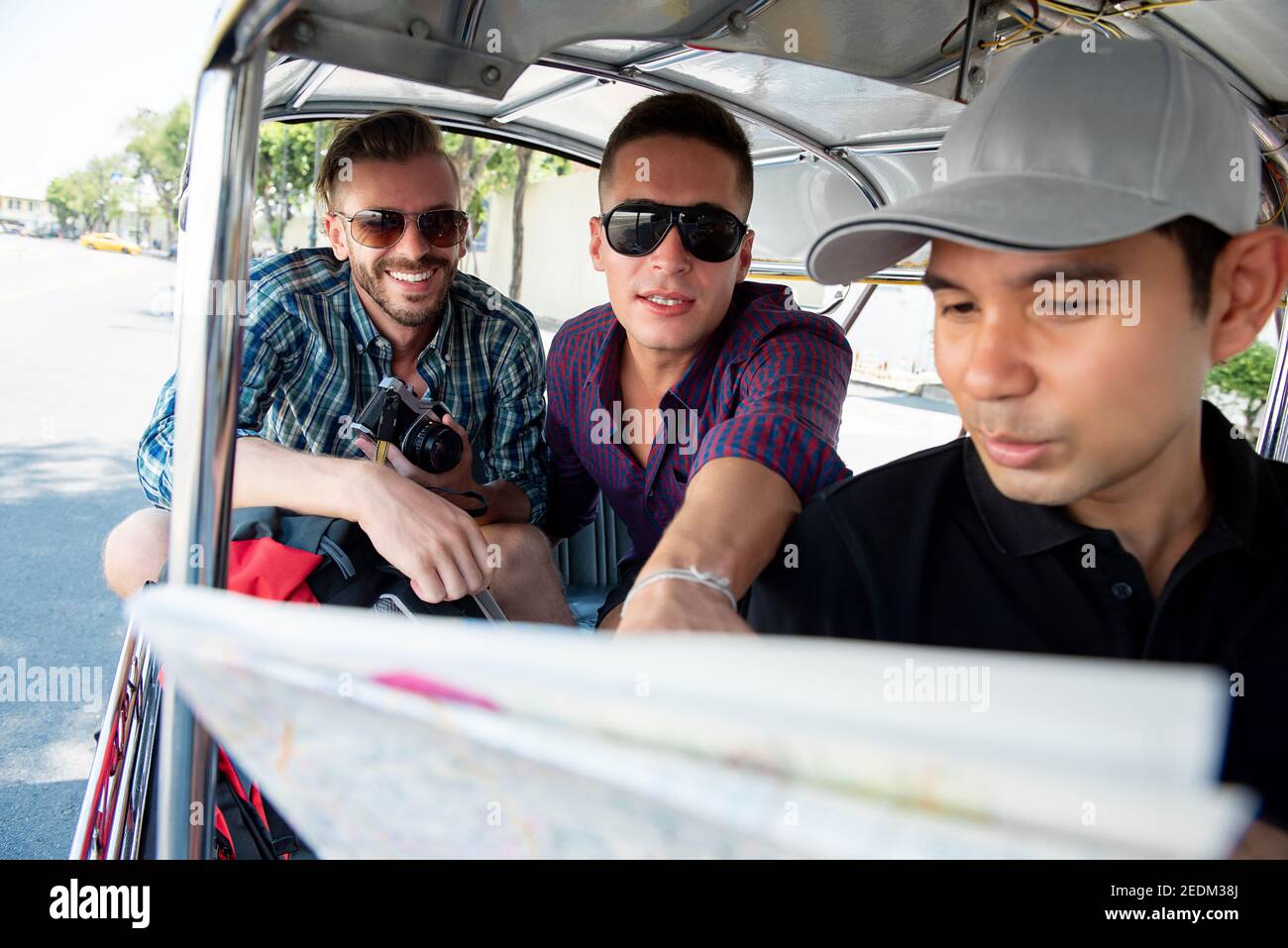 I turisti parlano con l'autista che chiede la posizione durante il viaggio Taxi locale Tuk Tuk a Bangkok Thailandia Foto Stock