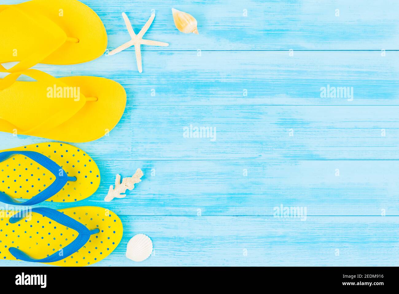 Estate vacanza sfondo spiaggia con infradito colorato su pannello di legno vintage blu chiaro, vista dall'alto con spazio per la copia Foto Stock