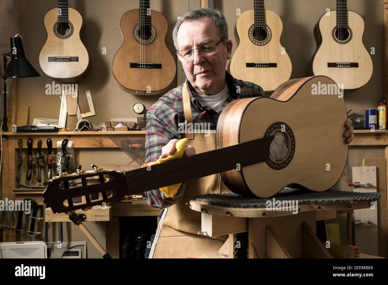 Il chitarrista gallese Paul Beauchamp lavora su una chitarra acustica fatta a mano nel suo laboratorio a Roath, Cardiff Foto Stock