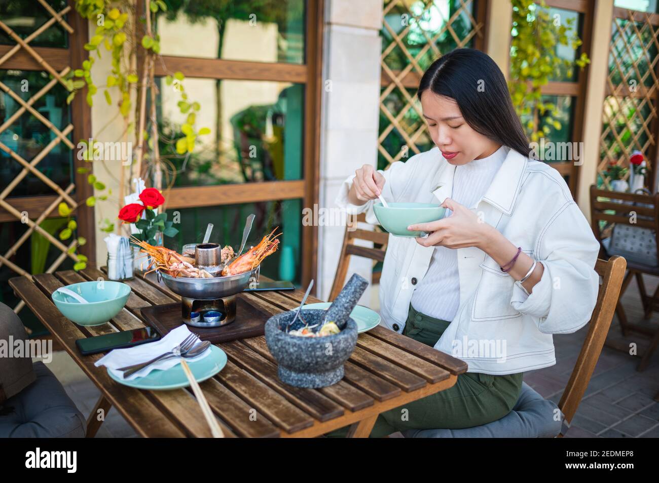 Donna asiatica che ha un pasto di cibo tailandese con tom zuppa di yum in un ristorante Foto Stock
