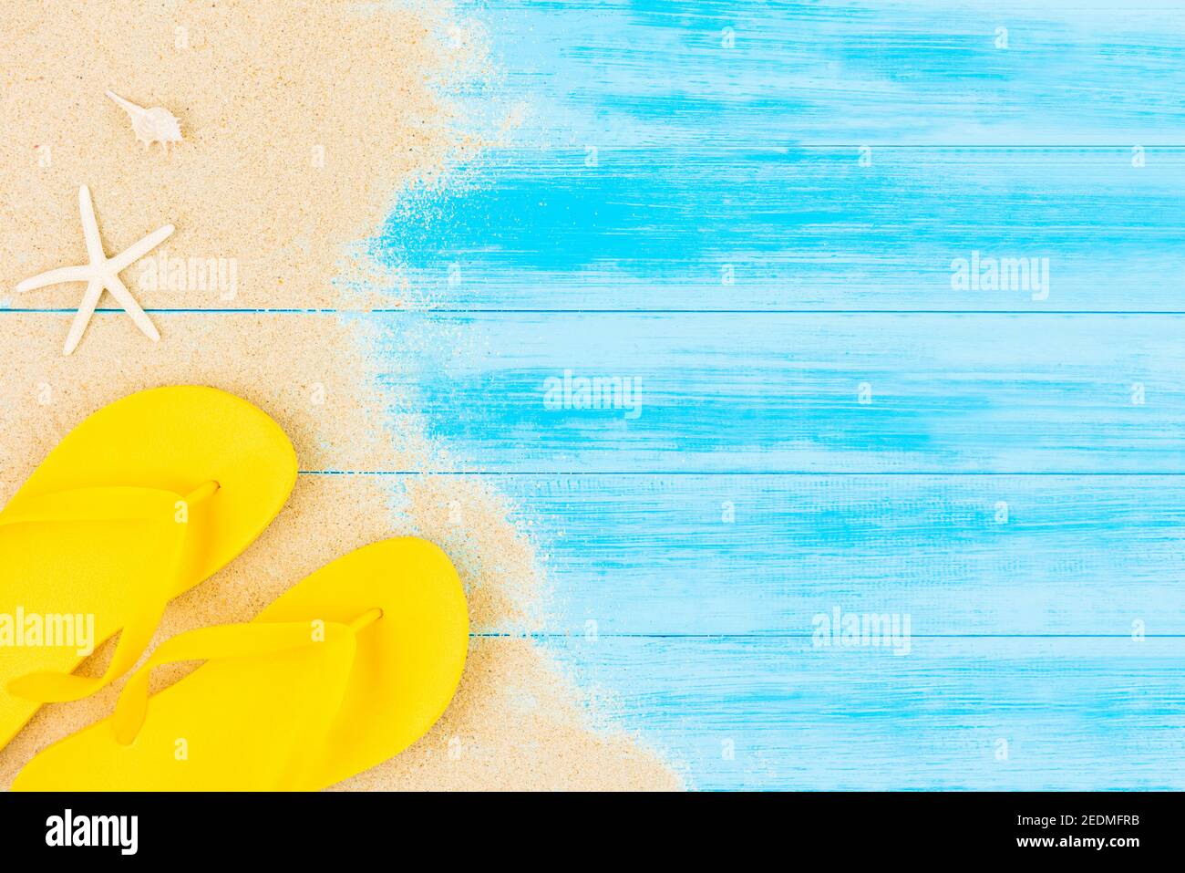 Sfondo delle vacanze estive con infradito colorato su pannello di legno vintage blu chiaro, vista dall'alto con spazio per la copia Foto Stock
