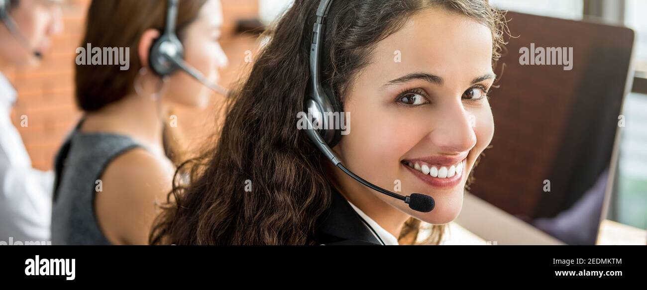 Bella femmina sorridente telemarketing servizio clienti agente woking in chiamata banner centrale - panoramico Foto Stock