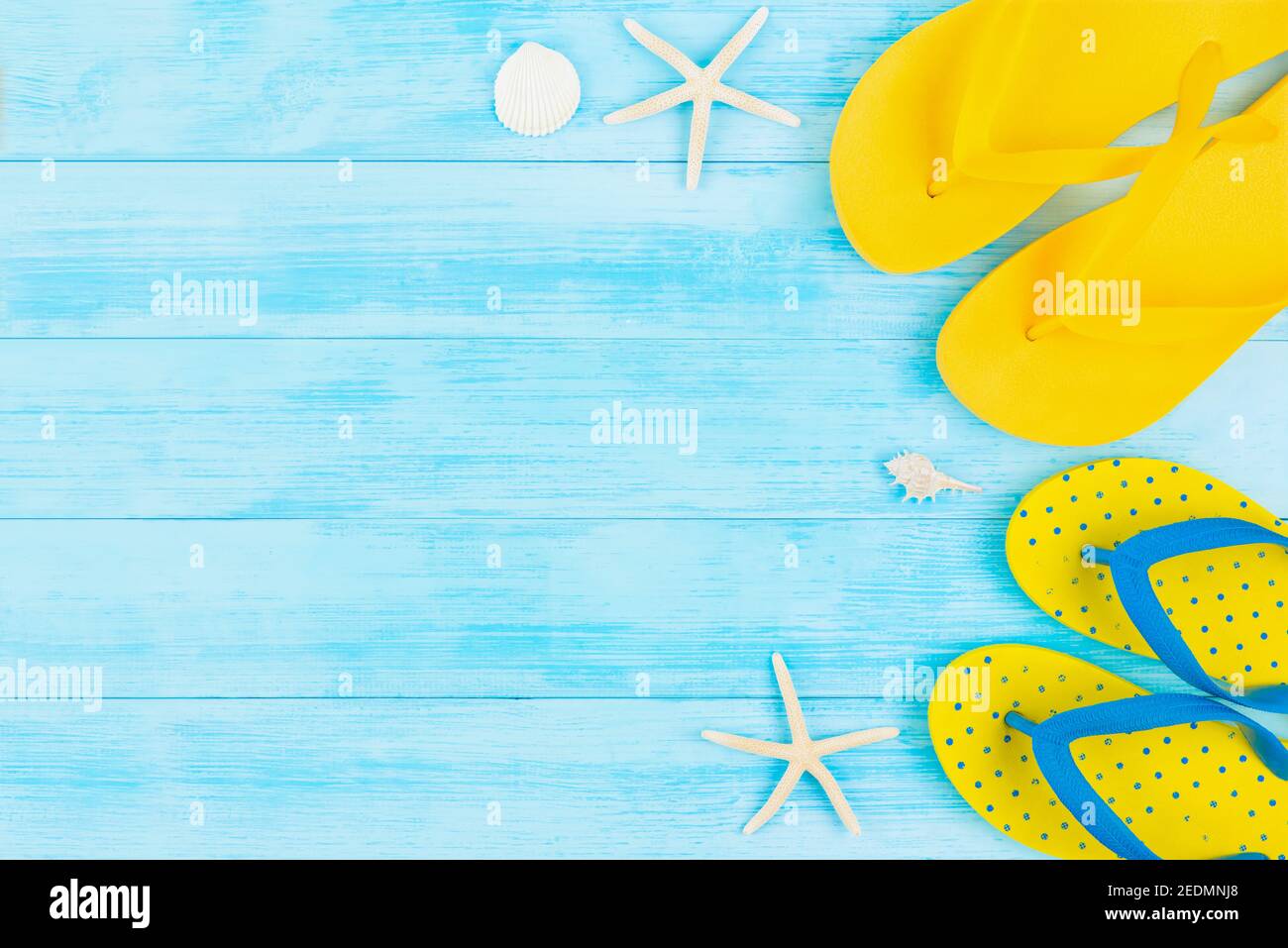 Estate vacanza sfondo spiaggia con infradito colorato su pannello di legno vintage blu chiaro, vista dall'alto con spazio per la copia Foto Stock