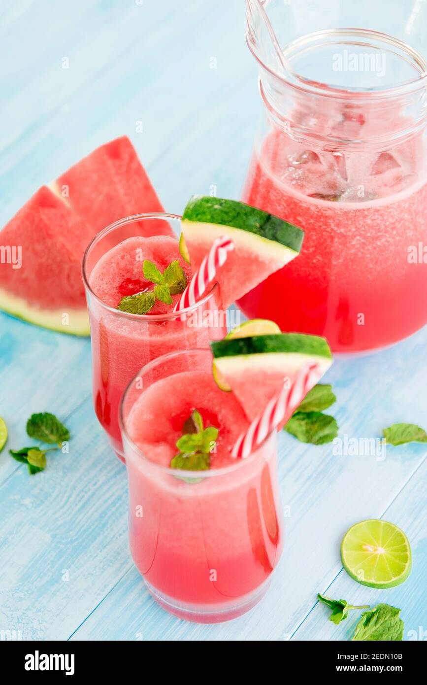 Bevande rinfrescanti colorate per l'estate, frullati freddi di succo di limonata di anguria nei bicchieri Foto Stock