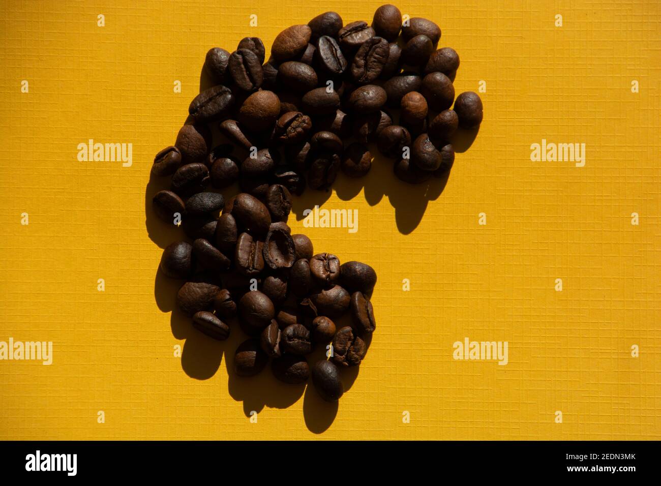 lettera c in chicchi di caffè tostati sfondo retrò stilizzato di colore giallo Foto Stock