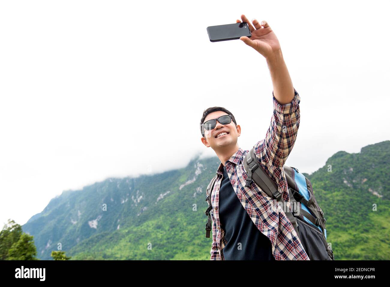 Uomo turistico asiatico indipendente prendendo selfie con montagna verde naturale Paesaggi durante le vacanze estive a Chiangmai Thailandia Foto Stock