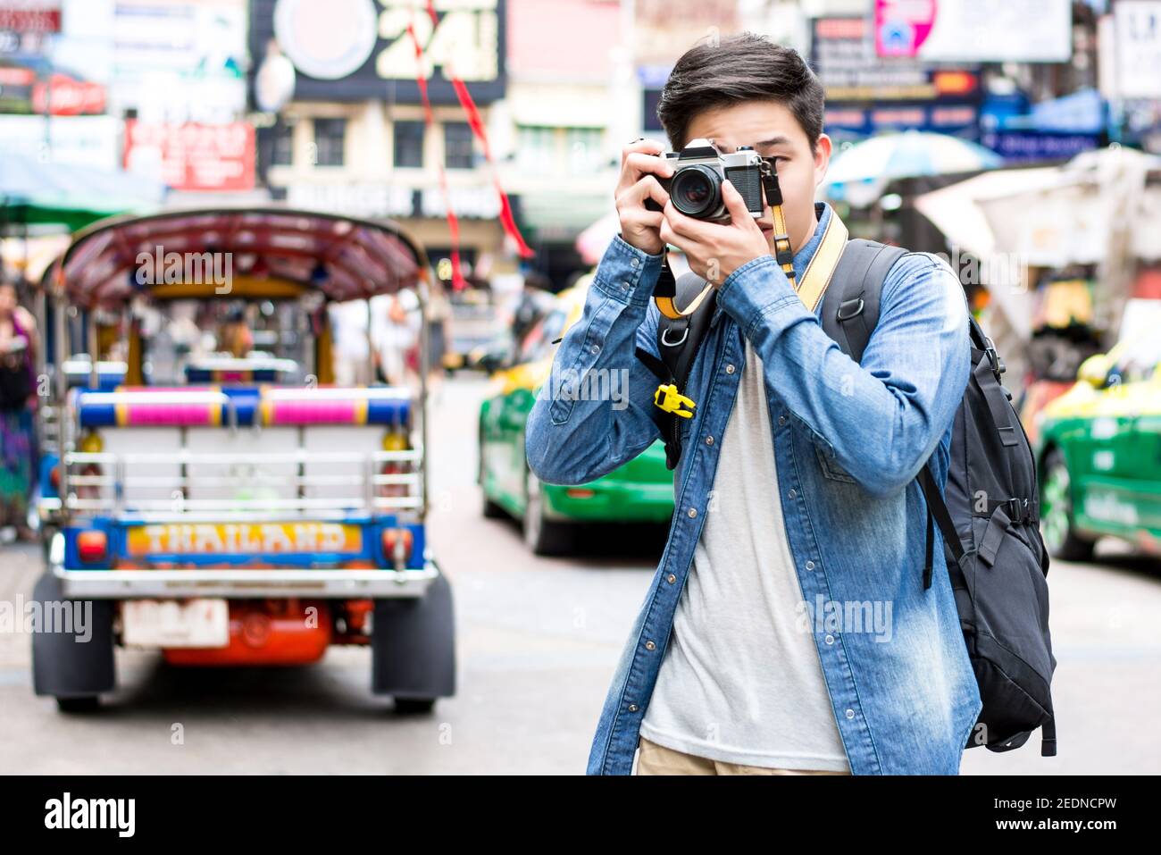 Giovane asiatico uomo indipendente fotografo turistico fotografare mentre si viaggia in Khao san Road, Bangkok, Thailandia in vacanza Foto Stock
