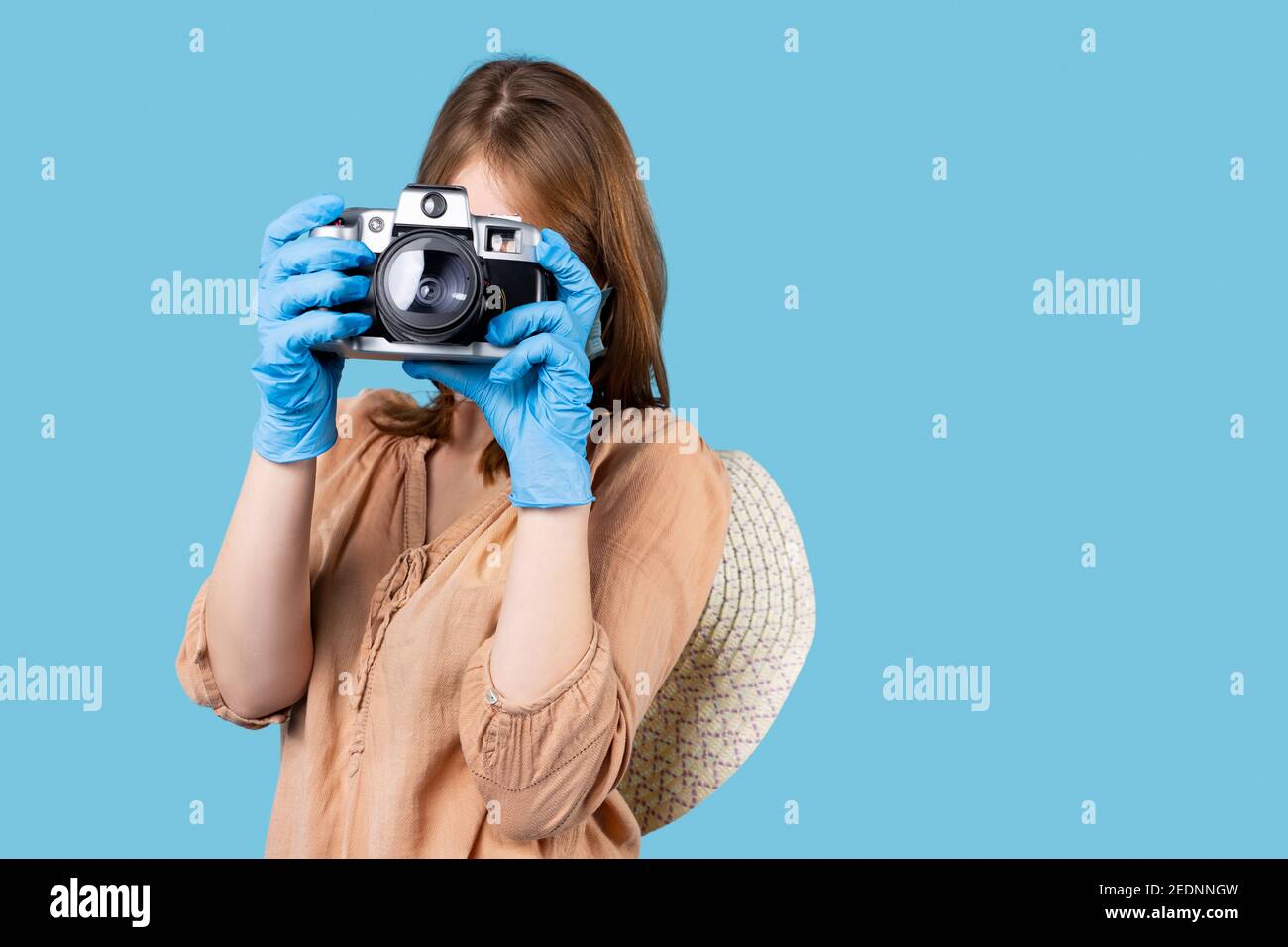 Una bionda in guanti medici lattice sta scattando foto con una macchina  fotografica vintage su uno sfondo con un posto per la pubblicità. Foto e  hobby durante un Foto stock - Alamy