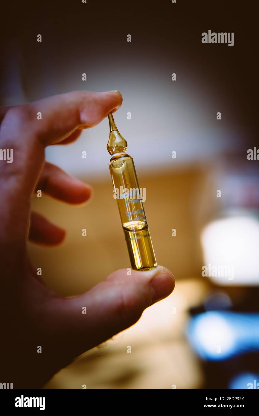 Ampolla di vetro per mano maschio POV con medicina Vitamina D. interno Foto Stock