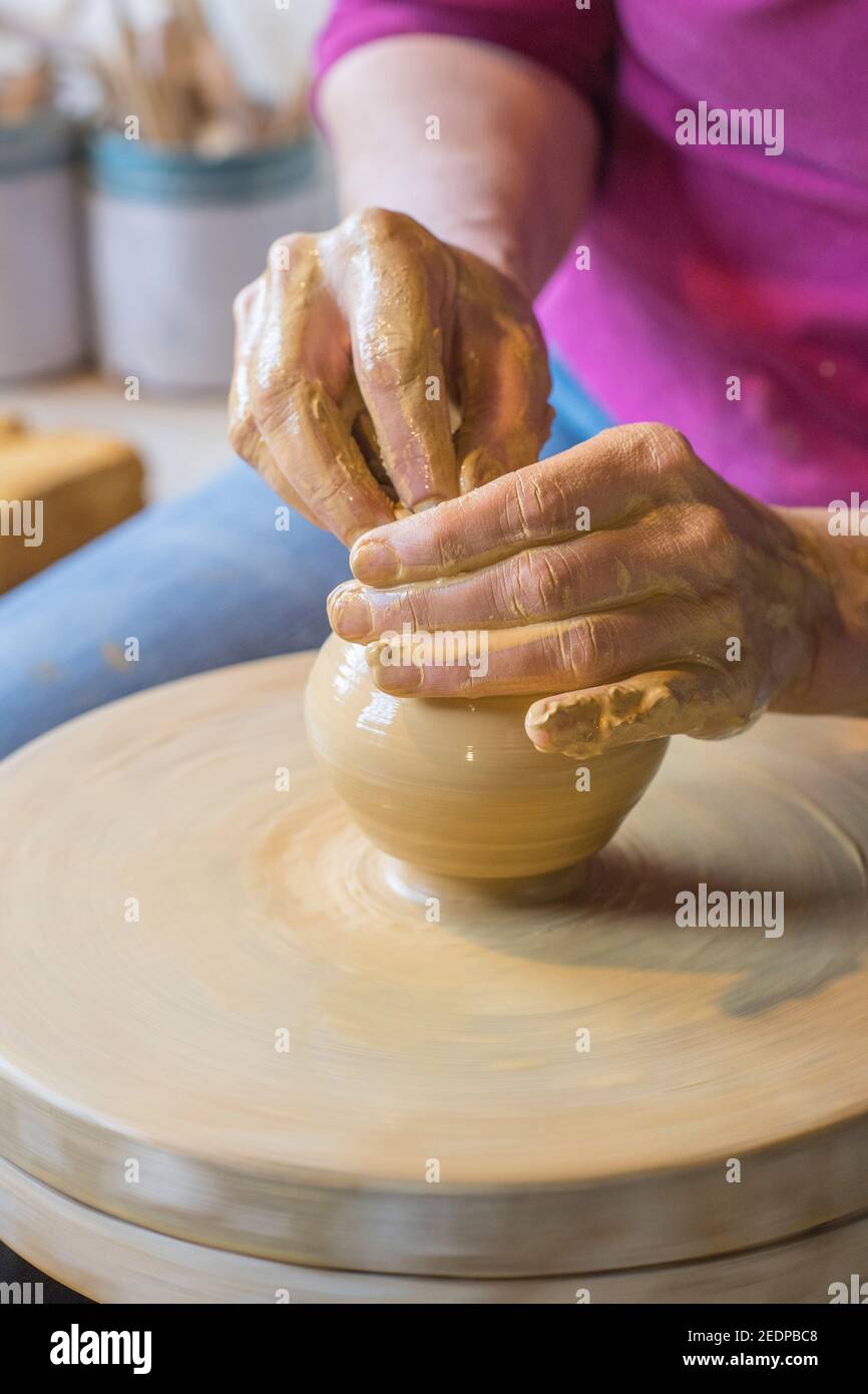 Vasaio femmina che forma un vaso da argilla in un laboratorio di ceramica, Germania Foto Stock