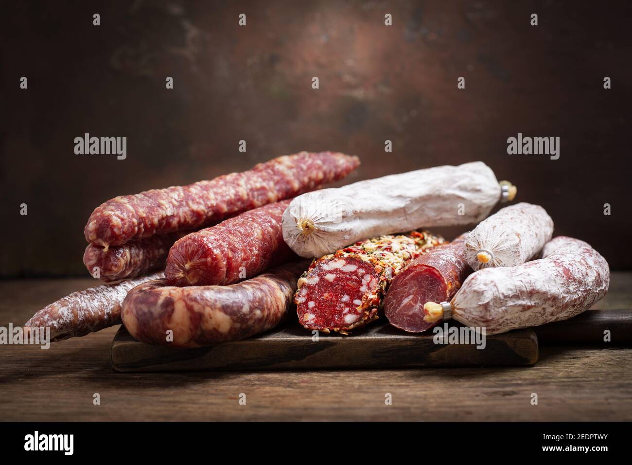 Vari tipi di salumi e salsicce su legno scheda Foto Stock